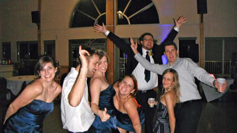 From wedding 1, DJ Hamilton, Groomsman in white shirts one with jacket and bridesmaids wearing beautiful dark blue gowns. All posing with arms stretched out and cheering. Taken in Hamilton Ontario